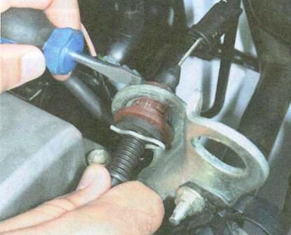 Извлечение наконечника оболочки троса привода дроссельной заслонки из отверстия в рыме Renault Logan