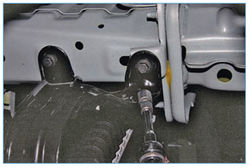 Откручивание затяжек четырех болтов крепления нижней поперечины радиатора к кузову Ford Focus 2