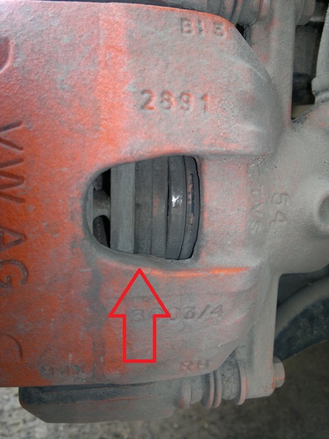 Проверьте через отверстие в корпусе суппорта состояние колодок тормозных механизмов передних колес на автомобиле Hyundai Solaris