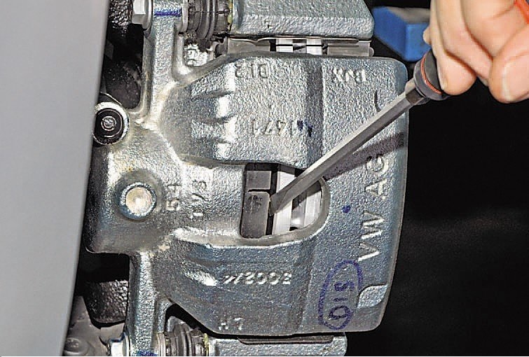 Проверка подвижности поршней и направляющих пальцев тормозных механизмов отверткой на автомобиле Hyundai Solaris