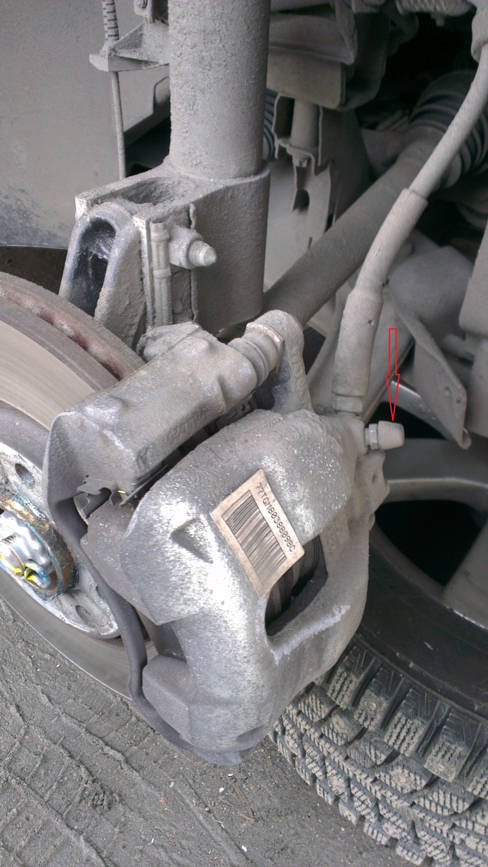 Очистите от грязи клапаны выпуска воздуха и снимите защитные колпачки клапанов рабочих цилиндров тормозных механизмов передних колес на автомобиле Hyundai Solaris