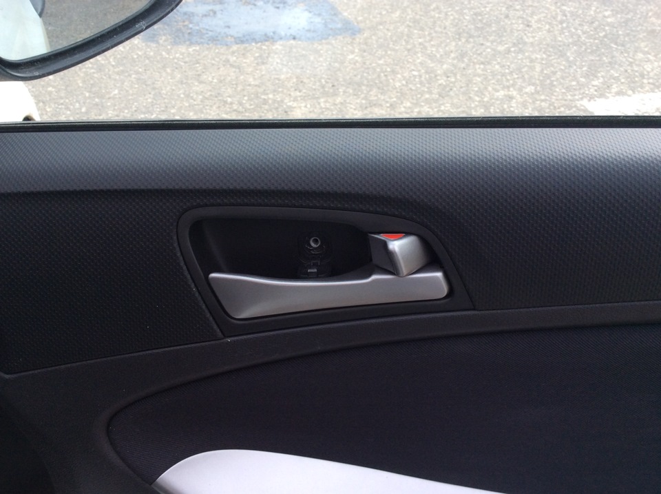 Отворачиваем саморез крепления декоративной накладки к внутренней панели двери на автомобиле Hyundai Solaris