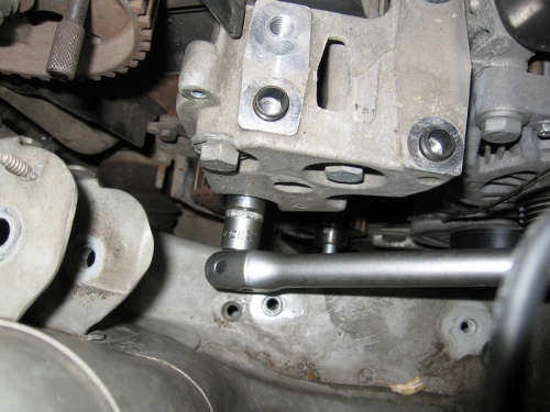 Откручивание нижнего болта обводного ролика ремня ГРМ дизельного двигателя Peugeot 407
