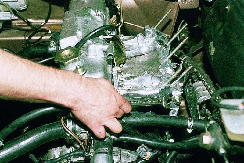 Откручивание гайки верхнего крепления левого кронштейна впускного коллектора 8-клапанного двигателя Лада Гранта (ВАЗ 2190)