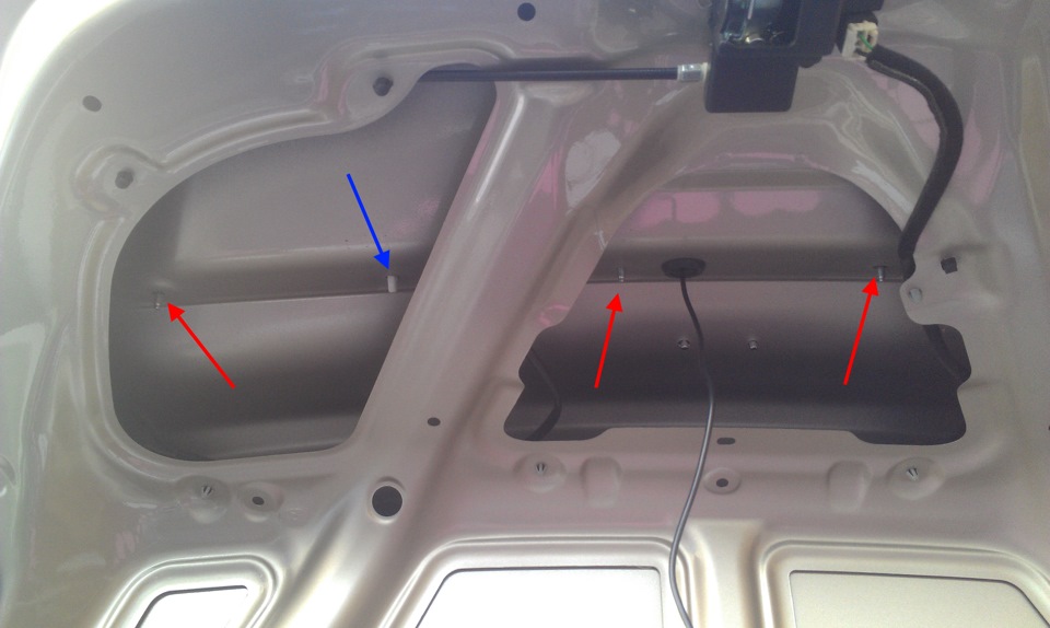 Отверните четыре гайки крепления декоративной накладки с внутренней стороны крышки багажника на автомобиле Hyundai Solaris