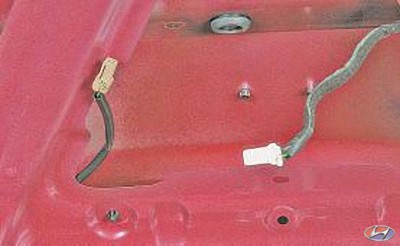 Отсоедините колодки двух жгутов проводов, расположенных на крышке багажника на автомобиле Hyundai Solaris