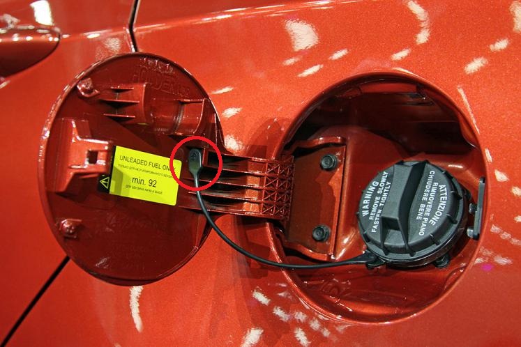 Отсоедините наконечник жгута пробки топливного бака от крышки люка наливной трубы на автомобиле Hyundai Solaris