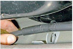 Извлечение оболочки троса стояночного тормоза из держателя на кузове автомобиля Lada Kalina