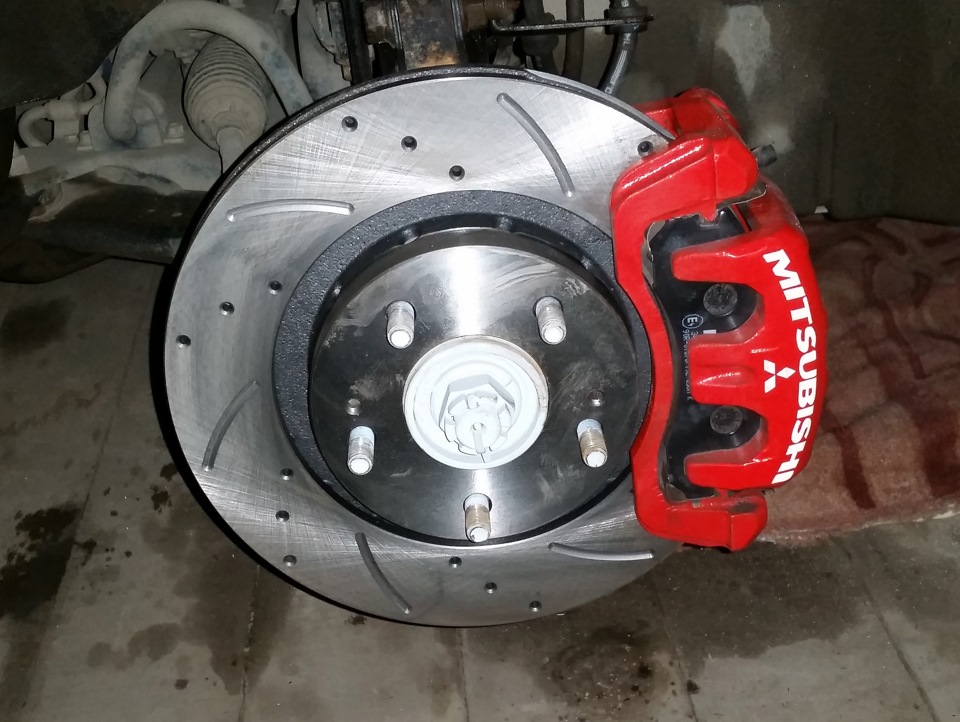 Новый тормозной диск и тормозные колодки на своем месте Mitsubishi Lancer X