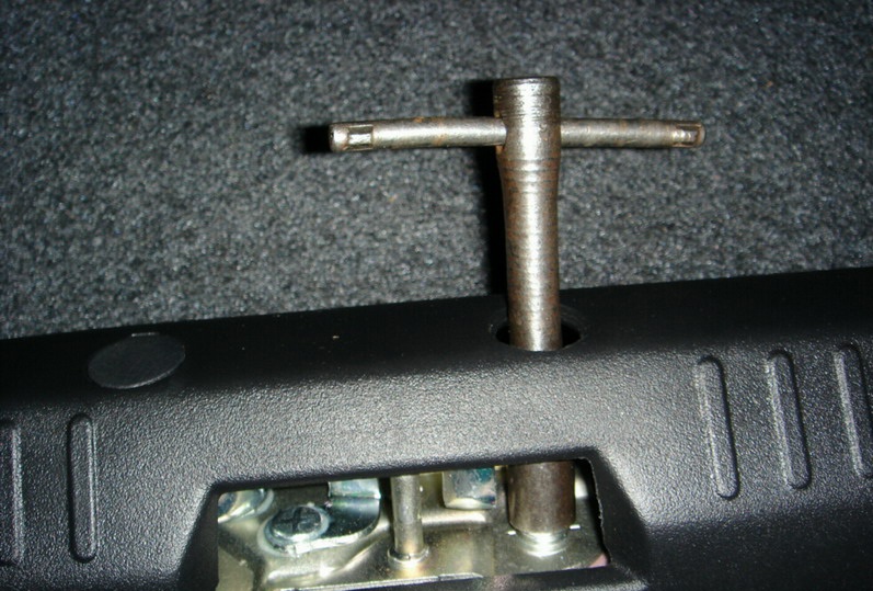 Ослабте два болта под заглушками при помощи гаечного Т-образного ключа Mitsubishi Lancer X