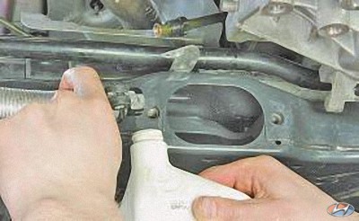 Слейте жидкость из напорного шланга системы гидроусилителя рулевого управления на автомобиле Hyundai Solaris