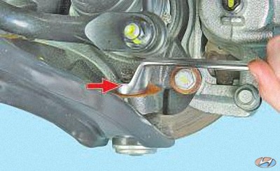 Отверните гайку крепления пальца шаровой опоры к поворотному кулаку на автомобиле Hyundai Solaris