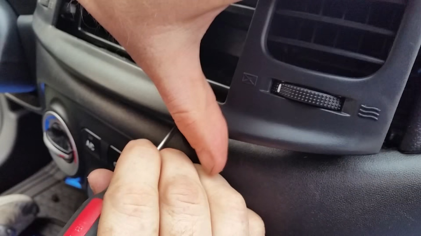 Подденьте нижние фиксаторы панели магнитолы на автомобиле Hyundai Accent MC