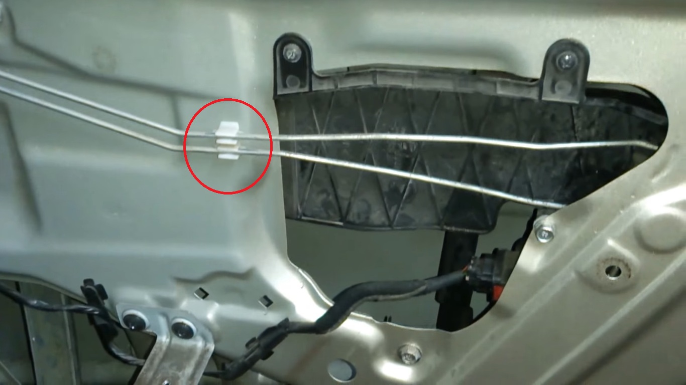 Извлечь тяги внутренней ручки замка задней двери из пластмассового фиксатора на автомобиле Hyundai Accent MC