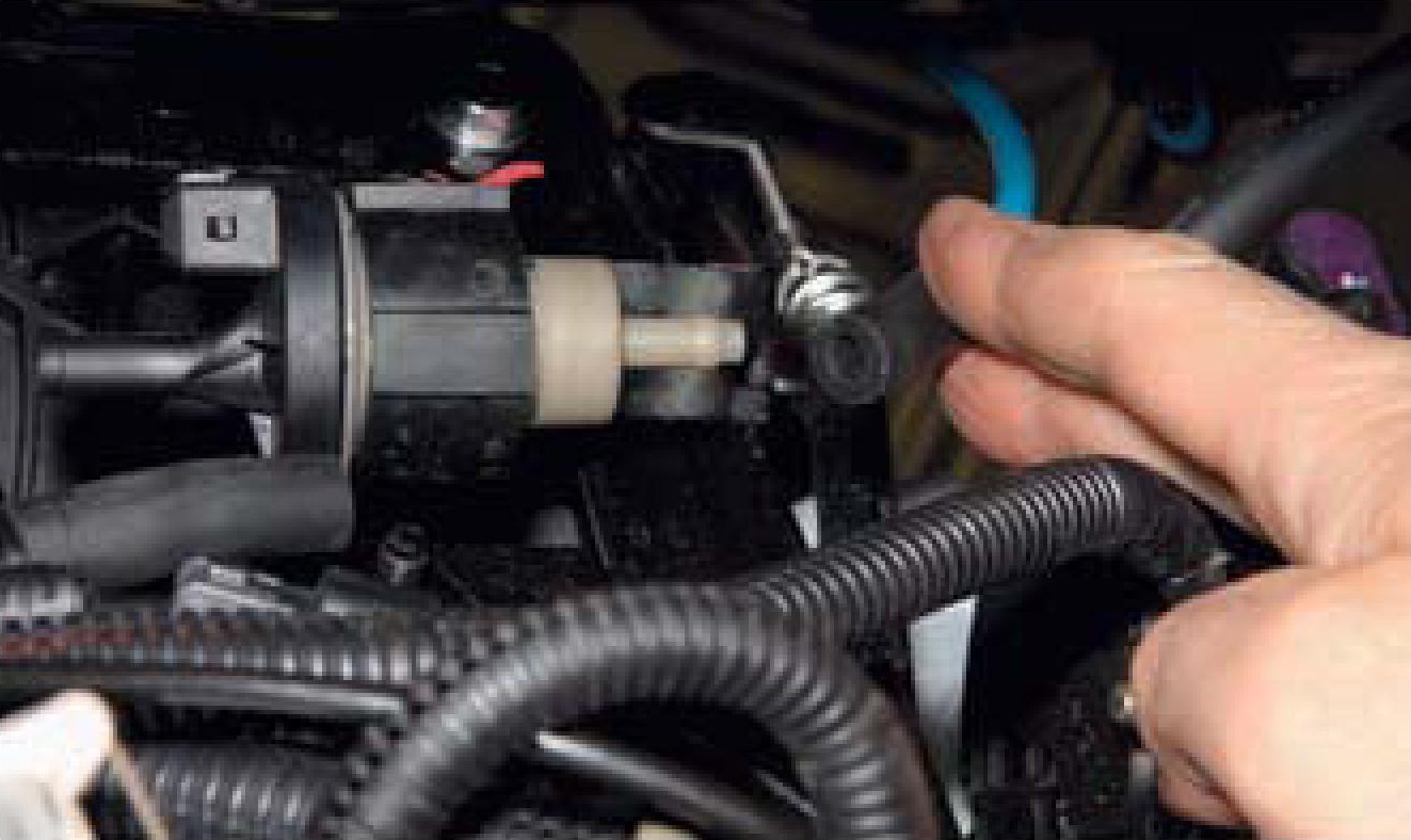 Отсоединение наконечника трубки подвода паров топлива от штуцера клапана продувки адсорбера топливной системы двигателя F16D3 Daewoo Nexia N150