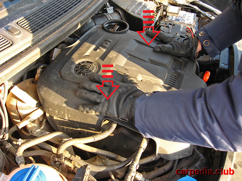 Прижать и защелкнуть фиксаторы декоративного кожуха двигателя на автомобиле Skoda Fabia MK2 5J 2007-2014