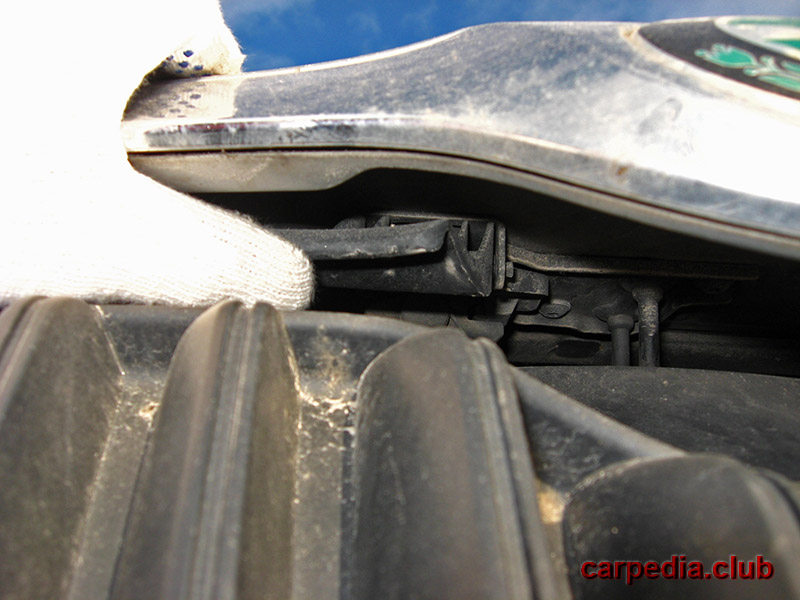 Нажать на рычаг открывания замка капота в передней части автомобиля Skoda Fabia MK2 5J 2007-2014