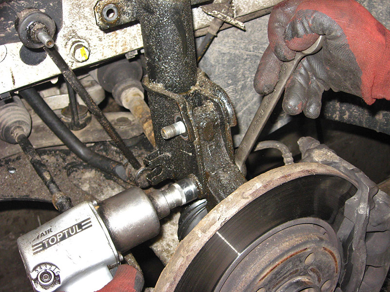 Открутить крепления переднего амортизатора на автомобиле Nissna Primastar 2001-2014