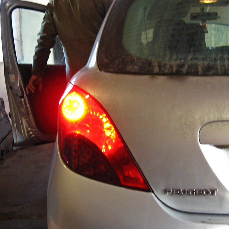 Включенный фонарь стоп-сигнала на автомобиле Peugeot 207
