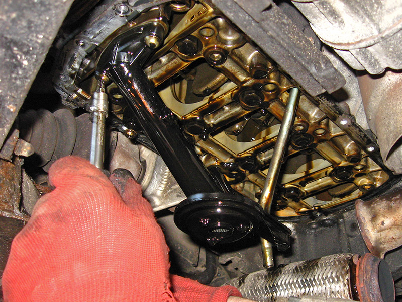 Выкручивание винтов крепления маслозаборника двигателя Peugeot 207