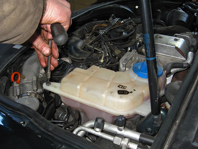 Открутить крепления бачка охлаждающей жидкости на Audi A6 4F/C6 2004-2011