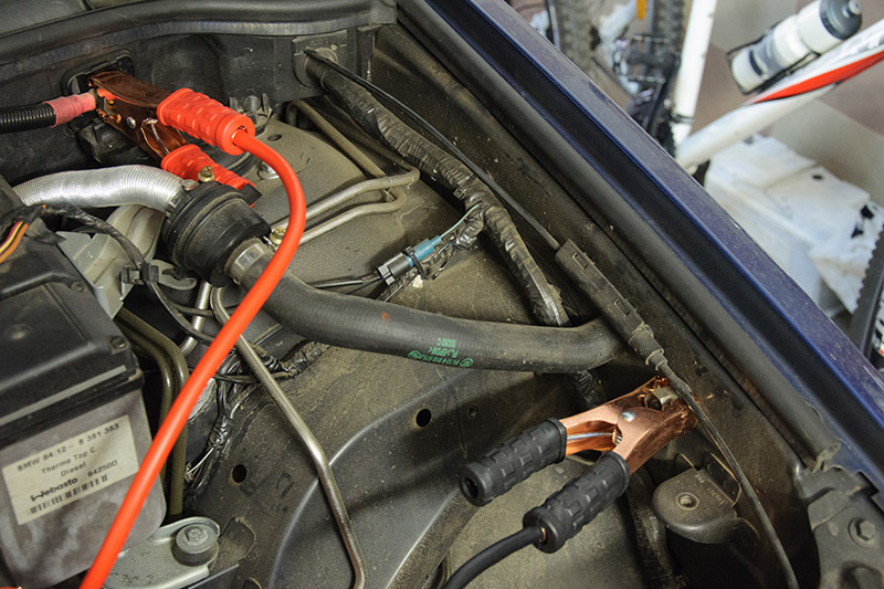 Закрепите зажим минус вспомогательного кабеля на специальном выводе массы автомобиля BMW X5 I E53 1999 - 2006