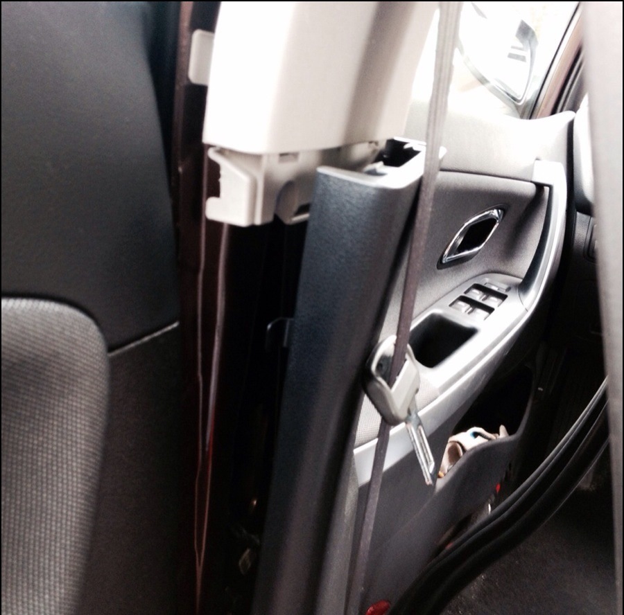 Преодолевая сопротивление упругих держателей снимите нижнюю облицовку центральной стойки на автомобиле Hyundai Solaris