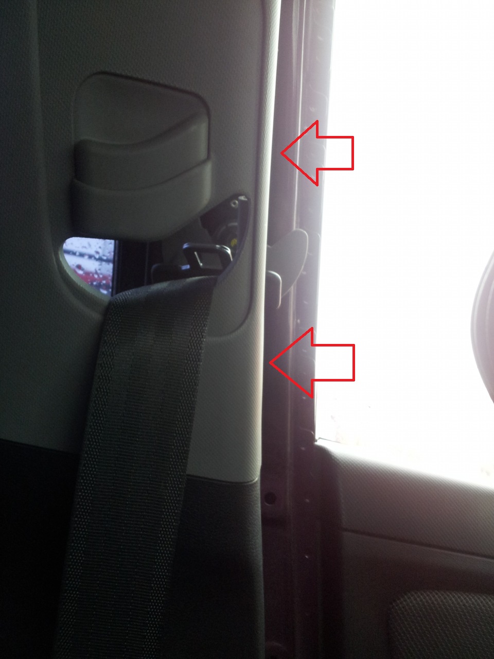 Преодолевая сопротивление упругих держателей, отведите верхнюю облицовку центральной стойки в сторону на автомобиле Hyundai Solaris
