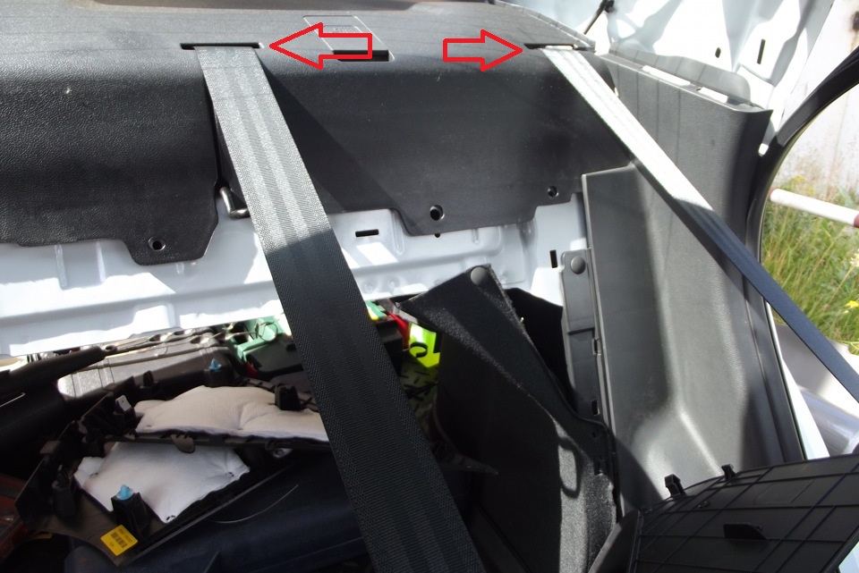 Выведите из прорезей в облицовке задней полки ремни безопасности задних пассажиров на автомобиле Hyundai Solaris