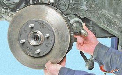 Выведите хвостовик наружного шарнира равных угловых скоростей из ступицы переднего колеса на автомобиле Hyundai Solaris