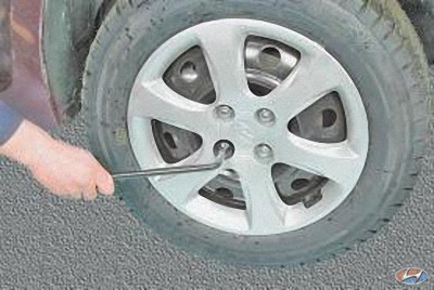 Отверните гайки крепления колеса и снимите декоративный колпак на автомобиле Hyundai Solaris