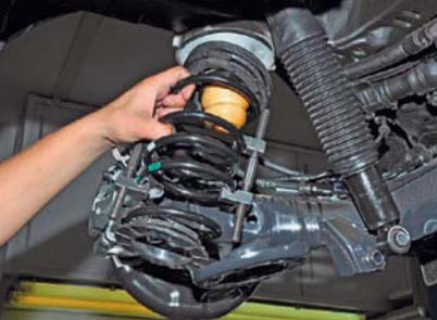 Отворачиваем болт нижнего крепления амортизатора к рычагу балки задней подвески на автомобиле Hyundai Solaris