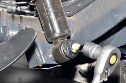 Отверните гайку нижнего крепления амортизатора на автомобиле Hyundai Solaris