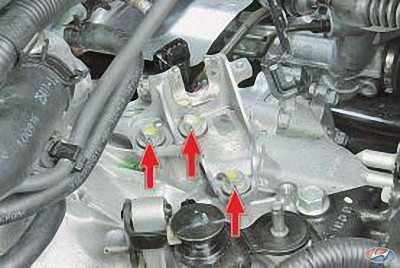 Выверните три болта крепления кронштейна тросов управления коробкой передач на автомобиле Hyundai Solaris