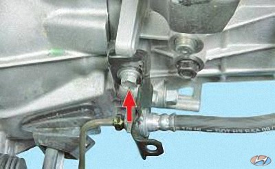 Выверните болт крепления кронштейна, трубопровода привода сцепления к корпусу коробки передач на автомобиле Hyundai Solaris