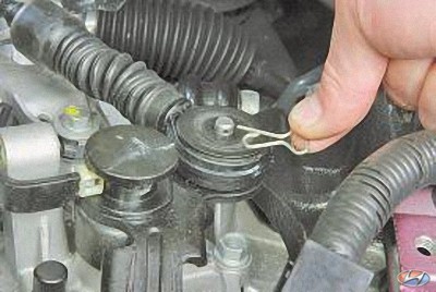 Извлеките шплинт крепления наконечника троса из отверстия оси рычага переключения передач на автомобиле Hyundai Solaris