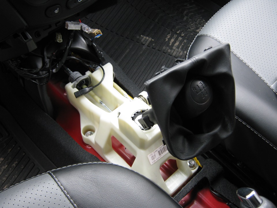 Приподнимите декоративный чехол рычага управления коробкой передач на автомобиле Hyundai Solaris