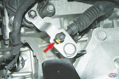 Отверните гайку крепления наконечника троса управления коробкой передач на автомобиле Hyundai Solaris