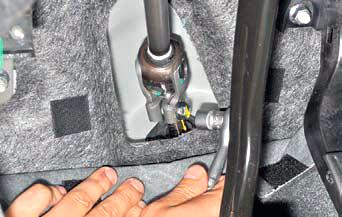 Отворачиваем болт крепления нижнего карданного шарнира промежуточного вала на автомобиле Hyundai Solaris