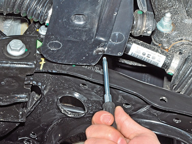 Откручивание ключом с наконечником Torx грязезащитного щитка моторного отсека Volkswagen Polo