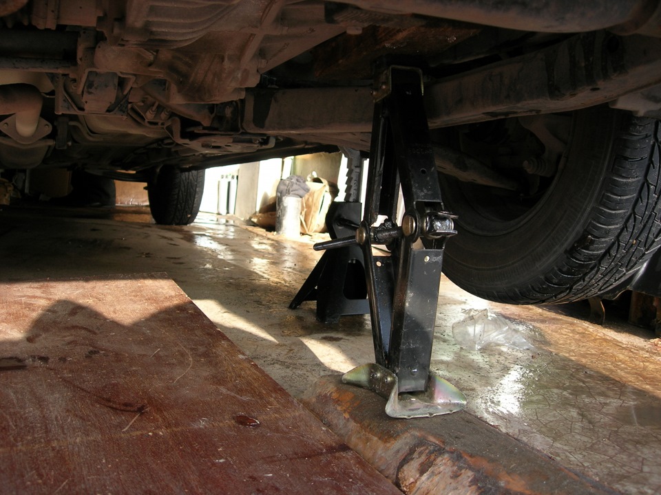 Устанавливаем через деревянный брусок надежную опору под картер коробки передач на автомобиле Hyundai Solaris
