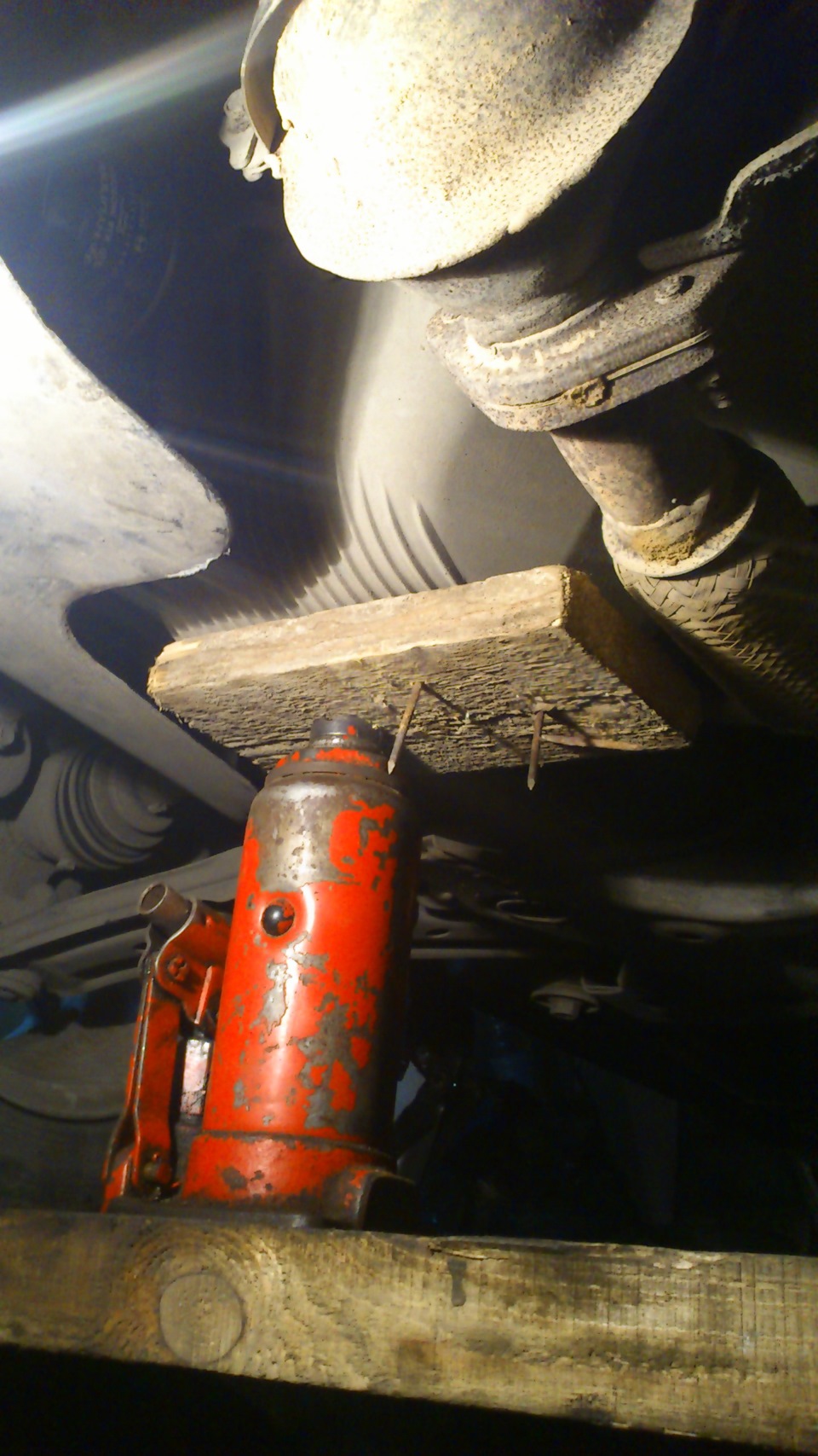 Устанавливаем через деревянный брусок надежную опору под крышку поддона картера двигателя на автомобиле Hyundai Solaris