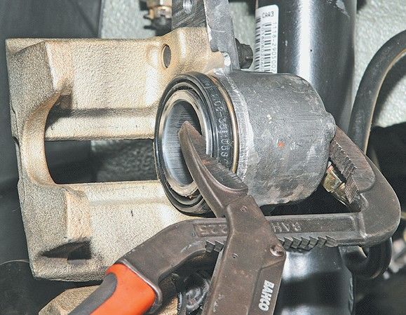 Утапливание с помощью плоскогубцев тормозного цилиндра в корпус суппорта Лада Гранта (ВАЗ 2190)