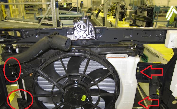 Отожмите четыре фиксатора крепления электровентилятора к радиатору на автомобиле Hyundai Solaris