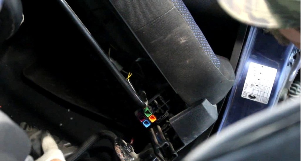 Отсоединение колодки жгута проводов, к которой подключается подогрев, преднатяжитель ремня безопасности и электропривод регулировки сиденья Ford Focus 2