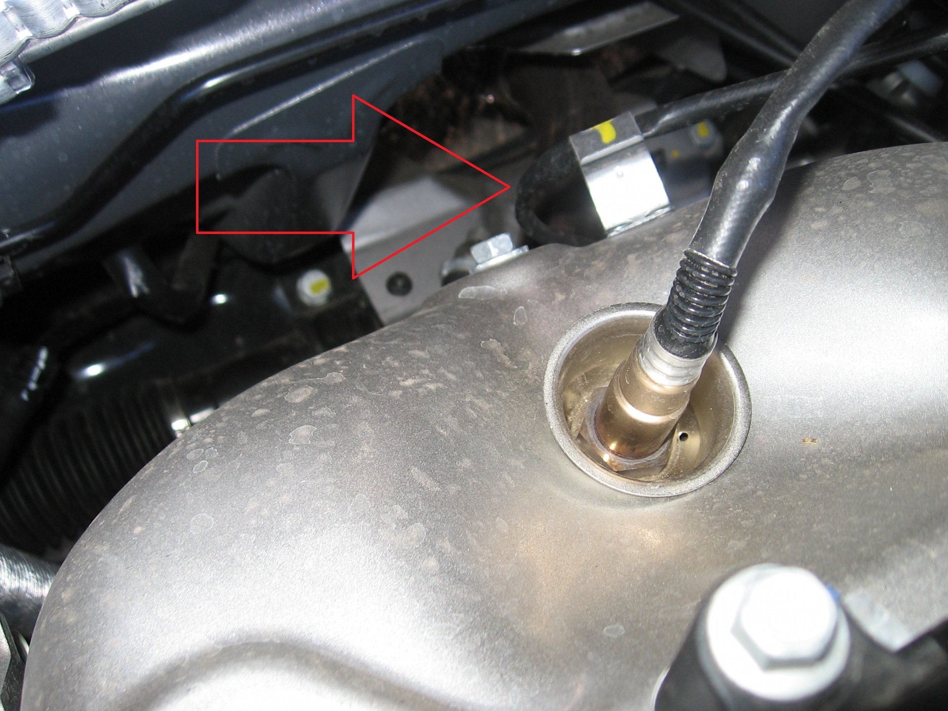 Вынимаем жгут проводов датчика из держателя теплозащитного экрана катколлектора на автомобиле Hyundai Solaris