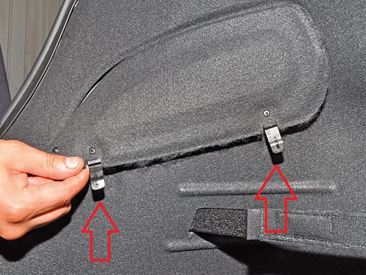 Отсоединить фиксаторы технологического отверстия в боковой облицовке багажника на автомобиле Hyundai Solaris