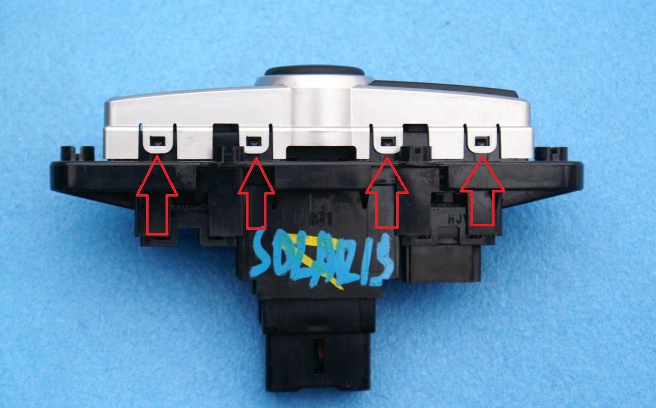 Отсоединить фиксаторы крепления декоративной накладки к рамке выключателя аварийной сигнализации на автомобиле Hyundai Solaris