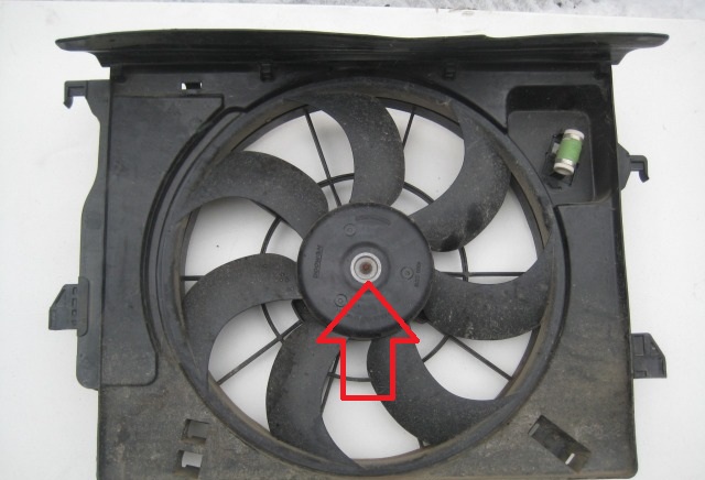 Отверните гайку крепления крыльчатки электровентилятора на автомобиле Hyundai Solaris