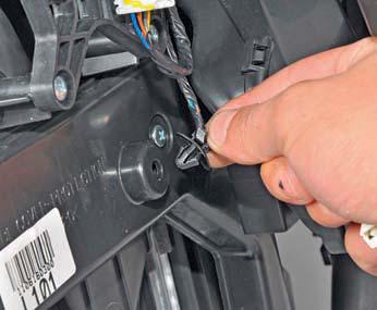 Отсоединяем держатель жгута проводов от крышки радиатора отопителя на автомобиле Hyundai Solaris